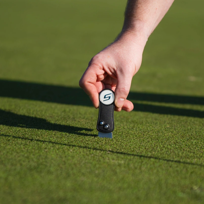 Golfer using Shot Scope divot tool