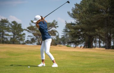 Female golfer hitting wood from fairway