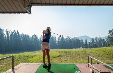 Female hitting shots at driving range