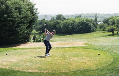 golfer teeing off