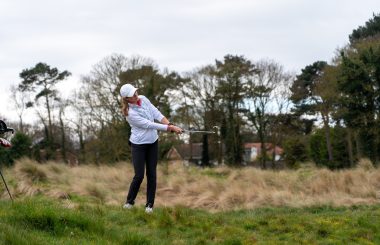 Female golfer hitting from rough