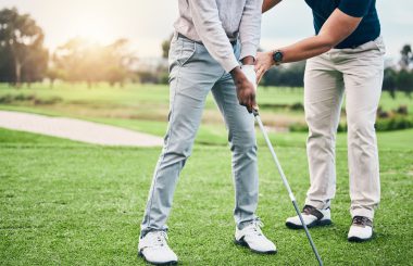 Golf coach teaching golfer