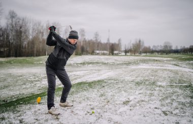 Man hitting tee shot from winter tee box