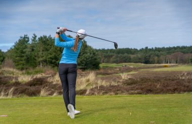 Female golfer with driver on tee box