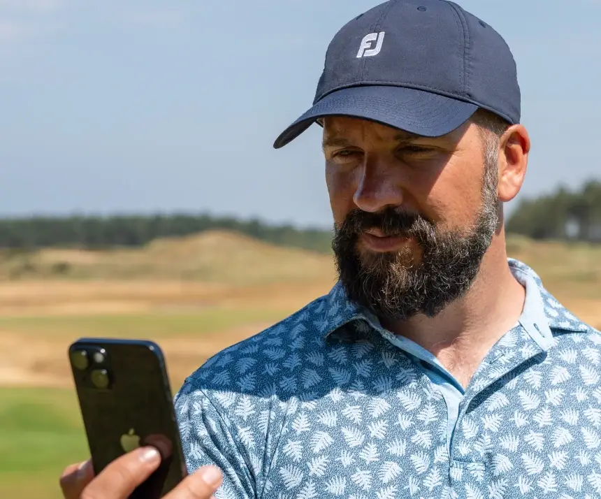 peter finch golf coach looking at his shot scope app