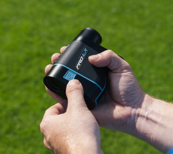 Male golfer holding blue PRO LX rangefinder turning on slope switch