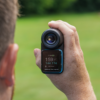 Male golfer holding Blue PRO LX+ rangefinder front back showing GPS handheld