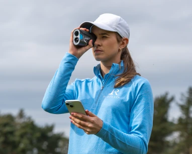 female golfer using pro zr laser rangefinder and using shot scope app