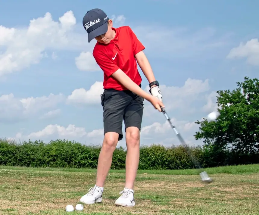 a young 12 handicap golfer hitting practise golf shots on the course