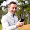 Shot Scope H50 GPS Handheld lifestyle showing golfer with GPS in hand