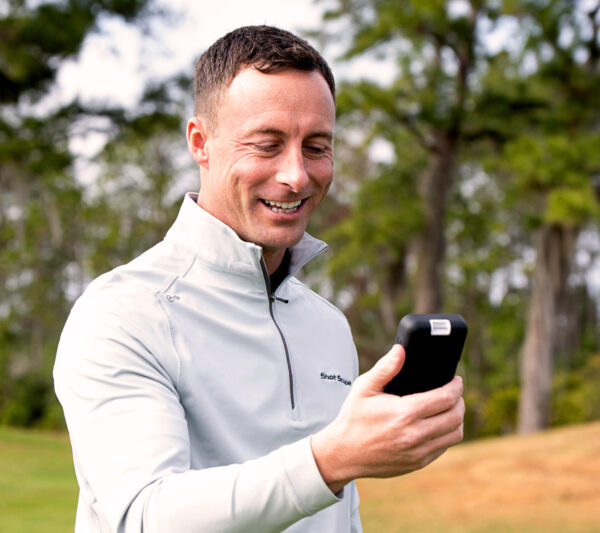 Shot Scope H50 GPS Handheld lifestyle showing golfer with GPS in hand