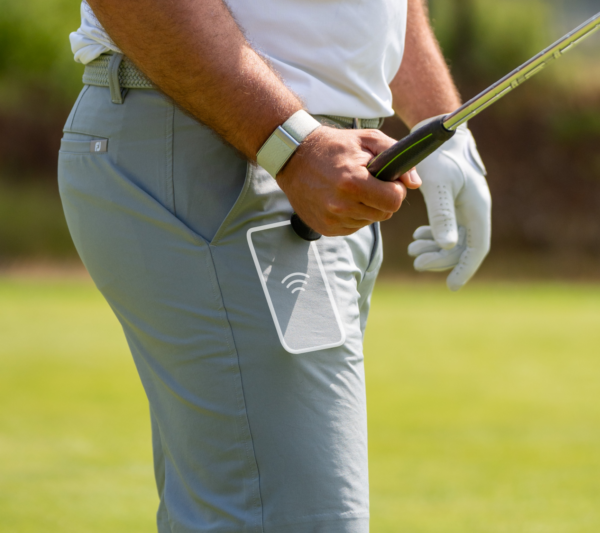 Male golfer tagging CONNEX tag against his mobile phone in his pocket