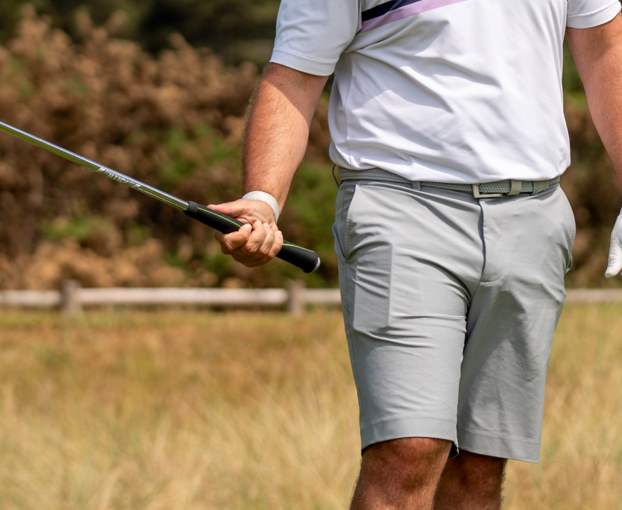 golfer tagging their phone in their pocket with their golf club to track their shot