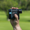 Male golfer holding Blue PRO LX rangefinder showing slope switch