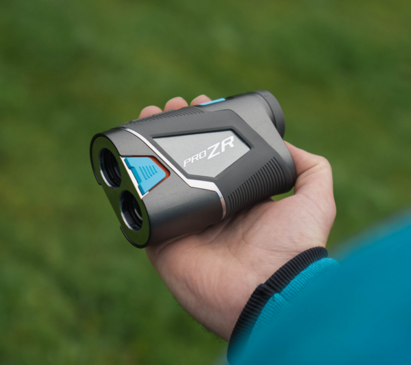 Male golfer holding PRO ZR rangefinder showing slope switch